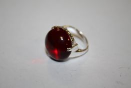 A SILVER LADIES DRESS RING SET WITH A RED POLISHED STONE, APPROX WEIGHT 10 G