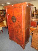 A CHINESE TWO DOOR LACQUERED CUPBOARD WITH RED PAINTED DETAIL H-177 W-107 CM