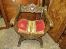 A CARVED OAK CEREMONIAL 'X' FRAME ARMCHAIR