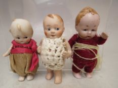 TWO EARLY 20TH CENTURY MINIATURE BISQUE KEWPIE DOLLS, tallest H 9 cm, together with a similar