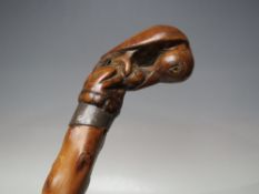 A WALKING CANE WITH A MATCHED CARVED HANDLE IN THE FORM OF A BIRD PECKING AT FRUIT, L 77 cm