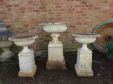 A SET OF THREE ANTIQUE CAST IRON URNS, raised on plinths, tallest H 107 cm, the pair approx H 84 cm,