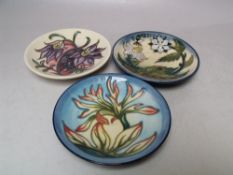 A COLLECTION OF THREE MOORCROFT PIN DISHES, to include an 'Indian Paintbrush' pattern example,