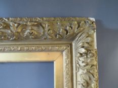 A 19TH CENTURY GOLD DECORATIVE FRAME WITH GOLD SLIP, frame W 12 cm, slip rebate 77 x 57 cm, frame