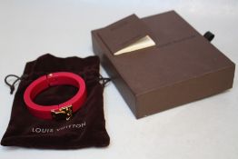 LOUIS VUITTON - A RESIN 'LOCK ME' HINGED BANGLE, with original box and Louis Vuitton drawstring bag