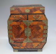 AN ORIENTAL STYLE INLAID TABLE CABINET, the hinged lid opening to a fitted interior, two small