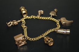 A HALLMARKED 9 CARAT GOLD CHARM BRACELET, approx weight 35gCondition Report:one small joining link