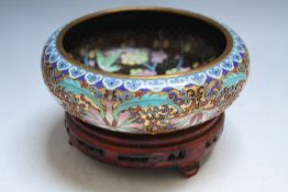 AN ORIENTAL TYPE CLOISONNE LOW BOWL, with internal decoration and hardwood stand, Dia 15.5 cm
