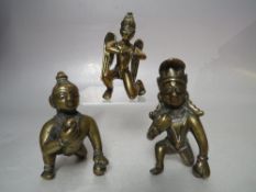 TWO EARLY GILT METAL DEITY FIGURES, tallest H 9 cm, together with a brass winged deity figure (3)