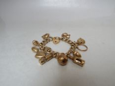 A HALLMARKED 9CT GOLD CHARM BRACELET, with eleven suspended yellow metal and hallmarked charms,