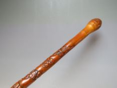 A VINTAGE ORIENTAL CARVED WAKING CANE WITH ROOT BALL KNOP, the shaft having multiple carved mask