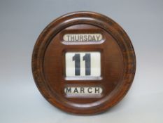 A VINTAGE WALL HANGING CIRCULAR OAK PERPETUAL CALENDAR, overall Dia. 31 cm