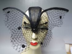 A HANDCRAFTED FASCINATOR BY K J MILLINERY IN THE FORM OF A BUTTERFLY, together with feather
