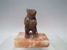A CARVED BLACK FOREST HIKING BEAR, on alabaster base, W 10.75 cm
