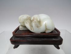 A SMALL JADE CARVING, on matched hardwood stand, W 9.5 cm