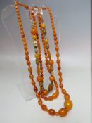 TWO VINTAGE AMBER BEAD NECKLACES, comprising a long length graduated example, approx weight 62 g,