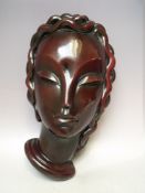 AN ART DECO STONEWARE WALL PLAQUE MODELLED AS THE HEAD OF A LADY, in the style of Goldscheider,