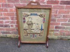 AN OAK FRAMED ORIENTAL THEMED TAPESTRY FIRESCREEN, the decorative glazed tapestry depicting two