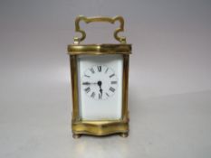 A FRENCH BRASS SERPENTINE FRONTED CARRIAGE CLOCK, H 12 cm