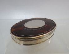 A GEORGIAN WHITE METAL AND TORTOISESHELL OVAL SNUFF, with vacant cartouche and pique work to