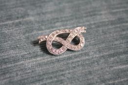 AN 18 CARAT WHITE GOLD DIAMOND SET STAFFORDSHIRE KNOT, set with an estimated 1.25 carats of