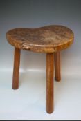 A ROBERT THOMPSON OF KILBURN MOUSEMAN BURR OAK KIDNEY SHAPED COW STOOL, on three tapered octagonal