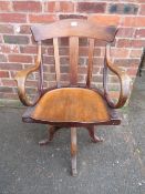 A VINTAGE OAK SWIVEL BENTWOOD ARMCHAIR