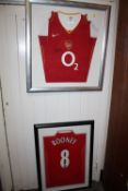 A FRAMED AND GLAZED SIGNED MANCHESTER UNITED WAYNE ROONEY FOOTBALL SHIRT, TOGETHER WITH AN ARSENAL