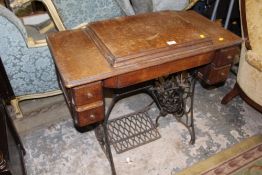 A VINTAGE OAK CASED SINGER TREADLE SEWING MACHINE