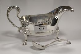 A HALLMARKED SILVER SAUCE BOAT TOGETHER WITH A PLATED LADLE