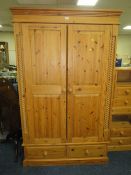 A LARGE PINE TWO DOOR WARDROBE WITH DRAWERS BELOW H-198 W-122 CM