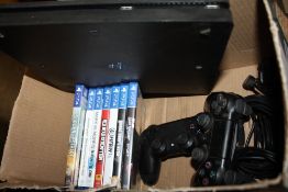 A SONY PS4 CONSOLE WITH TWO CONTROLLERS AND GAMES