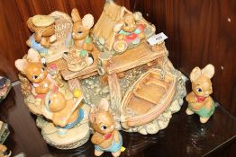 A COLLECTION OF PENDELFIN RABBITS ON DISPLAY STAND (8 ITEMS IN TOTAL)