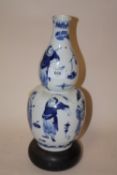 A CHINESE/ ORIENTAL BLUE AND WHITE CERAMIC DOUBLE GOURD VASE DECORATED WITH FIGURES HAVING FOUR