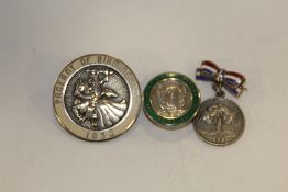 A HALLMARKED SILVER AND ENAMEL UNTIED STEEL COMPANIES BUTTON TOGETHER WITH AN ENAMELLED PAGEANT OF