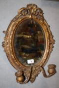 AN ANTIQUE GILT FRAMED OVAL MIRROR WITH SCONCES - OVERALL SIZE - 48 CM X 34CM