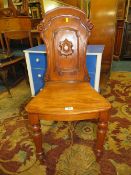 A 19TH CENTURY CARVED HALL CHAIR