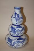 AN ORIENTAL STYLE BLUE AND WHITE STYLE TRIPLE GOURD VASE DECORATED WITH DRAGONS H 31 CM