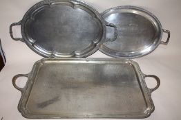 THREE WHITE METAL TWIN HANDLED SERVING TRAYS, LARGEST 69.5 CM BY 40.5 CM