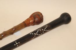 A VINTAGE EBONISED WALKING CANE WITH INLAID EMBELLISHMENT TOGETHER WITH ANOTHER EXAMPLE WITH A