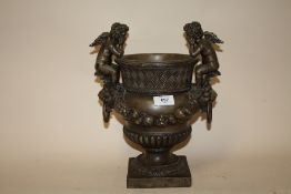 A MODERN RESIN TWIN HANDLED CHERUB URN, H 33 CM