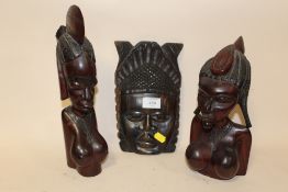 TWO CARVED WOODEN TRIBAL STYLE BUSTS TOGETHER WITH A WOODEN WALL HANGING MASK