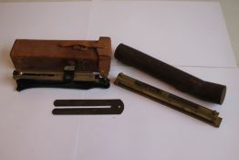 A CLINOMETER WITH MILIITARY MARKINGS IN LEATHER CASE, a brass level and a button cleaning stick