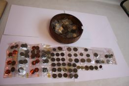 A WOODEN BOWL OF BRITISH AND WORLD COINS