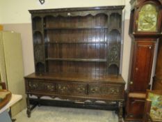 A 19TH CENTURY CARVED OAK THREE DRAWER WELSH DRESSER RAISED ON TURNED SUPPORTS WITH CARVED DETAIL