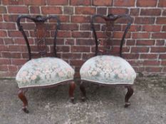 A PAIR OF EDWARDIAN LOW CARVED BEDROOM CHAIRS