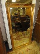 A CONTEMPORARY GILT FRAMED LARGE WALL MIRROR 138 X 78 CM