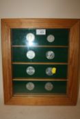 A PINE DISPLAY CASE CONTAINING COMMEMORATIVE COINS