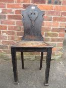 AN ANTIQUE CARVED OAK HALL CHAIR