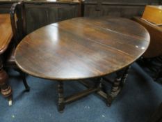 AN ANTIQUE OAK DROPLEAF TABLE ON TURNED SUPPORTS WITH SINGLE FRIEZE DRAWER
